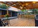 Covered outdoor patio with wood deck, fan, lighting, outdoor kitchen, and landscaped backyard at 2460 Worthington Rd, Maitland, FL 32751