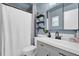 Bathroom featuring blue walls, a shower-tub combo, a mirrored vanity, and decorative shelving at 2471 Greenwood St, Deltona, FL 32738