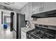 Modern kitchen with gray cabinets, tile backsplash, and a stainless steel gas range at 2471 Greenwood St, Deltona, FL 32738