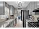A well-designed kitchen with gray cabinets, tile backsplash and stainless steel appliances at 2471 Greenwood St, Deltona, FL 32738