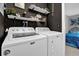 Laundry room with front-load washer and dryer, shelves with decor, and black textured wall at 2471 Greenwood St, Deltona, FL 32738