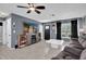 This living room has a ceiling fan, wall-mounted tv, tile floors, and modern furniture at 2471 Greenwood St, Deltona, FL 32738