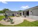 Back patio with lounge chairs, a dining table, and a screen door, surrounded by a green lawn at 2471 Greenwood St, Deltona, FL 32738
