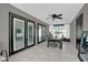 Bright sunroom with gray flooring, black framed french doors, and a dining table with seating at 2471 Greenwood St, Deltona, FL 32738