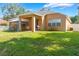 Spacious backyard featuring a covered patio with swing and well-maintained lawn, perfect for outdoor enjoyment at 2619 Breezy Meadow Rd, Apopka, FL 32712