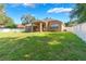 This backyard features a large grassy area, fire pit, covered porch, and white privacy fence at 2619 Breezy Meadow Rd, Apopka, FL 32712