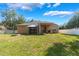 This backyard features a large grassy area, fire pit, covered porch, and white privacy fence at 2619 Breezy Meadow Rd, Apopka, FL 32712