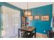 Cozy dining area features bright blue walls, tiled flooring, and decorative wall art and lighting at 2619 Breezy Meadow Rd, Apopka, FL 32712