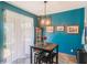Cozy dining room featuring bright blue walls, unique light fixture and door to the exterior at 2619 Breezy Meadow Rd, Apopka, FL 32712