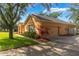 Exterior of a cozy home featuring a manicured lawn, landscaped garden beds, and an attached two-car garage at 2619 Breezy Meadow Rd, Apopka, FL 32712