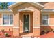 Close up of welcoming front porch with green door, decorative flower pots and mulch at 2619 Breezy Meadow Rd, Apopka, FL 32712
