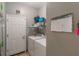 Well-lit laundry room with washer, dryer, shelving, calendar, and door to another room at 2619 Breezy Meadow Rd, Apopka, FL 32712