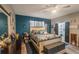 This main bedroom features wood floors, blue accent wall, and ensuite bathroom with glass door shower at 2619 Breezy Meadow Rd, Apopka, FL 32712