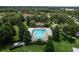 Community pool surrounded by lush landscaping with a covered lounge area in an aerial view at 2619 Breezy Meadow Rd, Apopka, FL 32712
