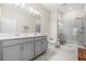 Modern bathroom with double sink vanity, walk-in shower with glass doors, and neutral tile flooring at 3007 Caneel St, Winter Haven, FL 33884