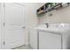 Functional laundry room with a washer, dryer, and storage shelving for supplies at 3007 Caneel St, Winter Haven, FL 33884