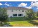 Home's backyard featuring a lush lawn, mature trees, and a view of the sliding glass doors at 316 Primrose Dr, Davenport, FL 33837