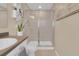 Bathroom featuring a walk-in shower with glass doors, neutral tiles, and modern fixtures at 316 Primrose Dr, Davenport, FL 33837