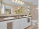 This is a stylish bathroom featuring dual sinks, modern fixtures, and a glass-enclosed shower at 316 Primrose Dr, Davenport, FL 33837
