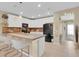 Modern kitchen with white cabinets, a center island with bar seating, and an open layout with a view to the entryway at 316 Primrose Dr, Davenport, FL 33837