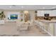 Open-concept living space featuring a dining area, modern barstools, and a stylish entertainment center with a TV at 316 Primrose Dr, Davenport, FL 33837