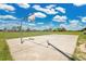 Community basketball court with two hoops surrounded by grass and fencing at 321 Thomasdale Ave, Haines City, FL 33844