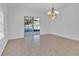 Open dining room area features tile flooring, chandelier, and sliding glass door access at 321 Thomasdale Ave, Haines City, FL 33844