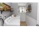 Well-organized laundry room featuring a washer, dryer, storage, and decorative accents at 341 Sprucewood Rd, Lake Mary, FL 32746