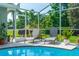 Relaxing screened-in patio with lounge chairs and a view of the lush backyard and inviting pool at 341 Sprucewood Rd, Lake Mary, FL 32746