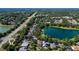 Aerial view of a neighborhood with lush trees, a pond, and multiple homes with pools at 402 S Lake Victoria Cir, Deland, FL 32724