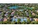 Community aerial view showcasing tennis courts, a pool, homes, and a lake surrounded by lush trees at 402 S Lake Victoria Cir, Deland, FL 32724