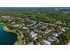 Aerial view of a neighborhood with a pond, mature trees, and lush landscaping at 402 S Lake Victoria Cir, Deland, FL 32724