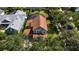 Aerial view of a well-maintained home with a brown roof, surrounded by lush greenery and mature trees in a serene setting at 402 S Lake Victoria Cir, Deland, FL 32724