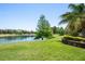 Scenic backyard with a serene lake view, mature trees, and lush green lawn at 402 S Lake Victoria Cir, Deland, FL 32724