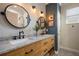 Well-lit bathroom featuring dual sinks, granite countertop, framed mirrors, and stylish tile flooring at 402 S Lake Victoria Cir, Deland, FL 32724