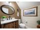 Well-lit bathroom featuring modern vanity, toilet, and decorative mirror at 402 S Lake Victoria Cir, Deland, FL 32724