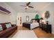 Comfortable bedroom features a ceiling fan, a leather sofa, and surfboards hanging on the wall for a unique decorative touch at 402 S Lake Victoria Cir, Deland, FL 32724