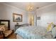 Bright bedroom featuring decorative light fixture, neutral walls, and patterned bedding at 402 S Lake Victoria Cir, Deland, FL 32724