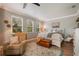 Inviting bedroom showcasing natural light, a cozy chair, a decorative rug, and wood flooring for a warm, relaxing ambiance at 402 S Lake Victoria Cir, Deland, FL 32724