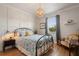 Cozy bedroom with a decorative light fixture, grid accent wall, and a large window at 402 S Lake Victoria Cir, Deland, FL 32724