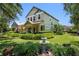 Attractive two-story home with a manicured lawn, decorative fountain, and a welcoming front porch at 402 S Lake Victoria Cir, Deland, FL 32724
