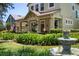 Beautiful two-story home with a manicured lawn, decorative fountain, and a welcoming front porch at 402 S Lake Victoria Cir, Deland, FL 32724