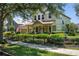 Beautiful two-story home with a manicured lawn, decorative fountain, and a welcoming front porch at 402 S Lake Victoria Cir, Deland, FL 32724