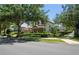 Attractive two-story home with a manicured lawn, decorative fountain, and mature trees at 402 S Lake Victoria Cir, Deland, FL 32724