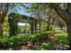 Picturesque garden featuring a charming arbor and serene lake views at 402 S Lake Victoria Cir, Deland, FL 32724