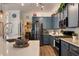 Open concept kitchen featuring stainless steel appliances, quartz countertops, and stylish blue cabinetry at 402 S Lake Victoria Cir, Deland, FL 32724