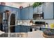 The kitchen features stainless steel appliances, quartz countertops, and custom blue cabinetry at 402 S Lake Victoria Cir, Deland, FL 32724