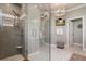 Elegant bathroom featuring dual vanities, custom mirrors, wood cabinetry, shiplap accent wall, and glass-enclosed shower at 402 S Lake Victoria Cir, Deland, FL 32724