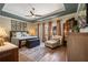 Spacious main bedroom featuring tray ceiling, wood floors, sitting area, and a wall of windows for abundant natural light at 402 S Lake Victoria Cir, Deland, FL 32724