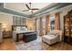 Spacious main bedroom featuring tray ceiling, wood floors, sitting area, and a wall of windows for abundant natural light at 402 S Lake Victoria Cir, Deland, FL 32724